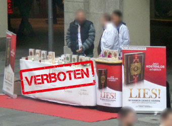 Drei Männer an einem salafistischen „LIES“-Stand.